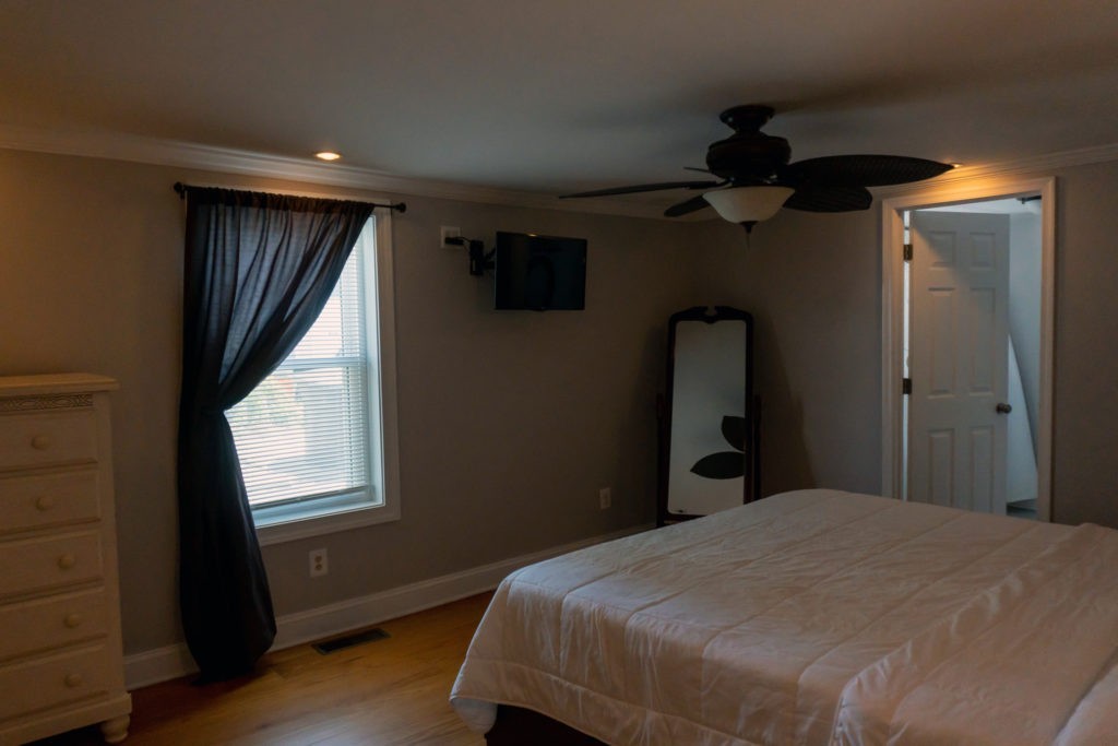 bedroom with kind size bed, ceiling fan, and dresser